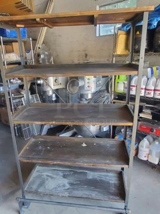 Industrial-style 5-tier shelf, metal frame, wooden shelves, used condition, signs of wear, ideal for storage or display.