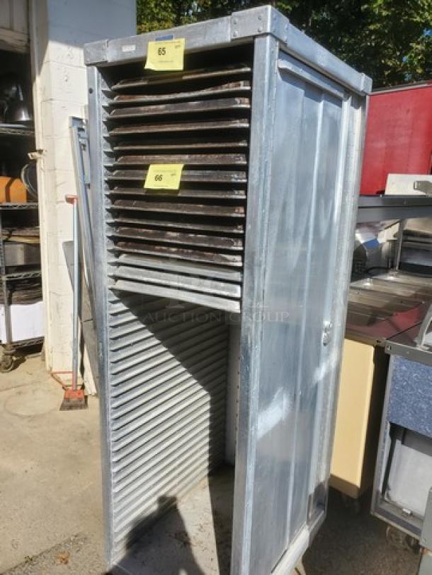 Mobile sheet pan rack, metal construction, used condition. No sheet pans included. Visible labels: "65" and "66."