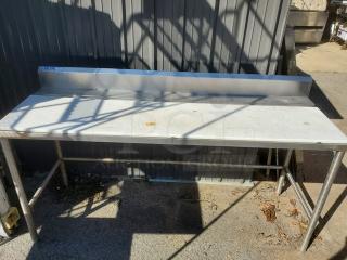 Stainless steel work counter with backsplash, showing minor surface rust stains. Durable construction, ideal for kitchens.