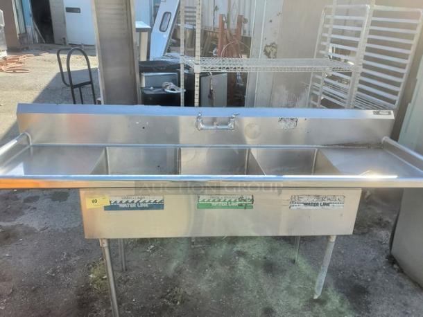 Three-compartment stainless steel sink, used, with visible "Master Line" label, sturdy legs, ideal for commercial kitchens.