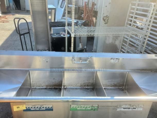 3 Compartment Stainless Steel Sink with visible water line labels, showing wear and rust. Commercial grade, ideal for kitchens.