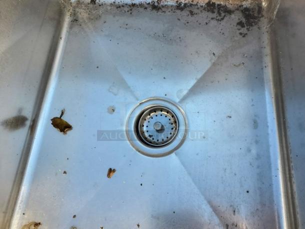 3 compartment stainless steel sink with visible wear and dirt, features central drainage, suitable for kitchen use.