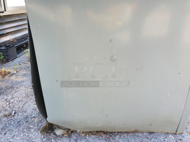 Vintage metal cabinet with signs of wear and rust on lower section; outdoor setting.