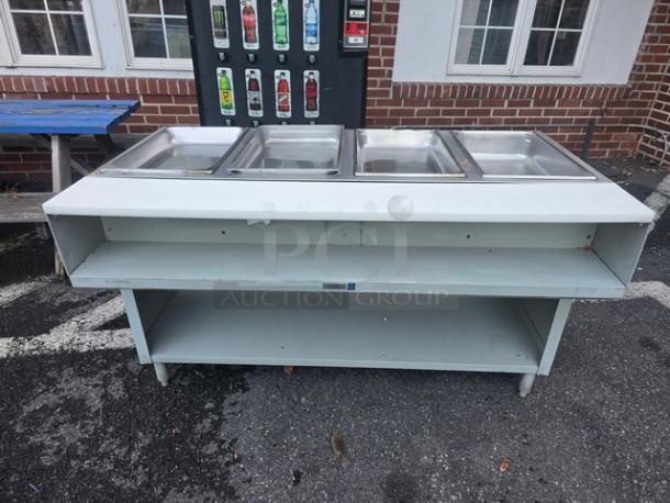 4 well propane steam table in good condition, with stainless steel pans and under-shelf storage, ideal for catering.