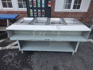 4 well propane steam table in good condition, with stainless steel pans and under-shelf storage, ideal for catering.
