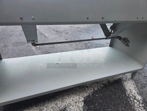4 well steam table in used condition, propane-fueled, with sturdy metal construction. Ideal for food service.