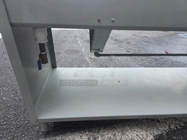 4 Well Steam Table, propane-operated, metal construction, used condition, visible plumbing connections. Ideal for food service.