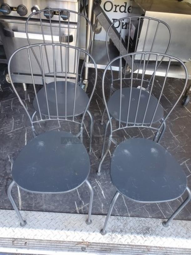 Lot of 4 black metal patio chairs, sturdy construction, lightly used, suitable for outdoor use, perfect for garden or patio.