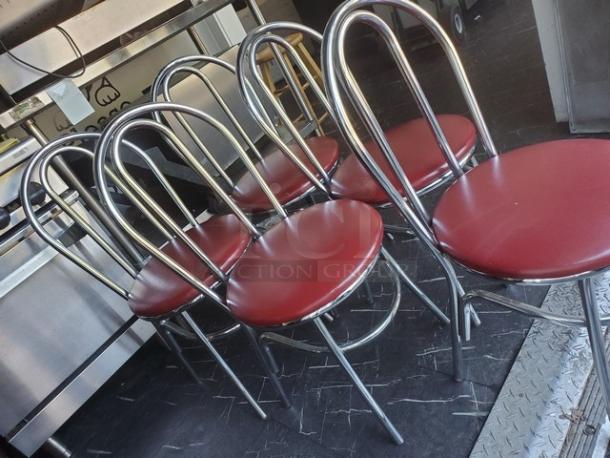 Lot of 4 red cushioned dining chairs with chrome frames, arched backs, used condition, suitable for dining rooms.
