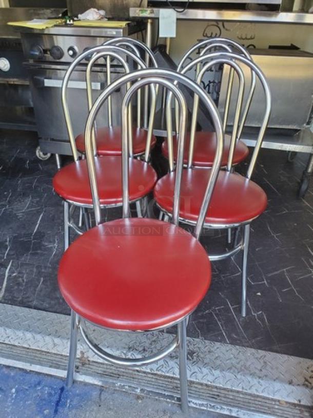 Lot of 4 dining chairs with red cushioned seats, chrome frames, arched backs. Good condition. Ideal for modern dining.