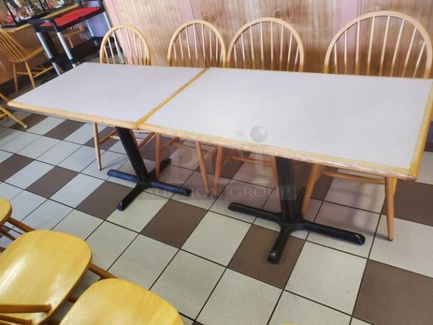 Lot of 2 rectangular dining tables with light laminate tops and black metal pedestal bases. Good condition.