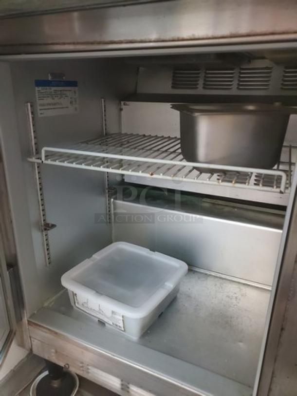 Beverage Air SUR48-18M 48" sandwich prep table interior. Visible wire shelves, clean condition, two-door design.