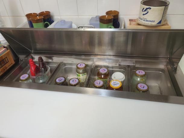 Avantco 178SCL2 48" Sandwich Prep Table in stainless steel, lid open. Contents not included. Appears in good condition.