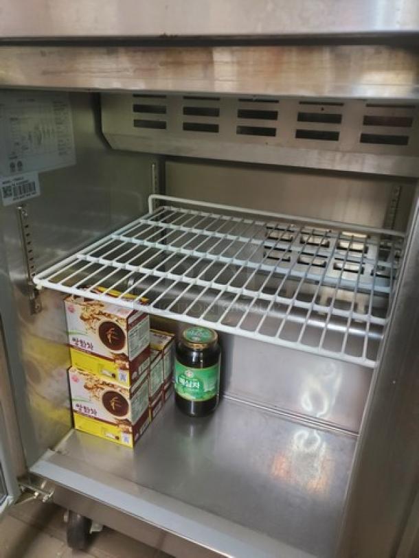 Avantco 178SCL2 48" sandwich prep table interior, stainless steel, with wire shelf. Contents seen are not included.