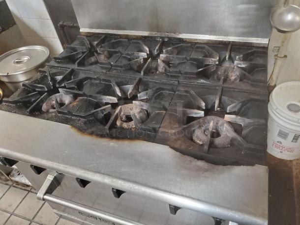 American Range 6 Burner Natural Gas Range, stainless steel, visible signs of use, ideal for commercial kitchens.