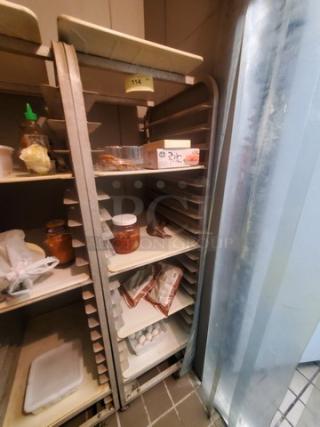 Sheet pan rack with multiple slots, metal frame, sturdy condition. Contents not included. Ideal for kitchen or bakery use.