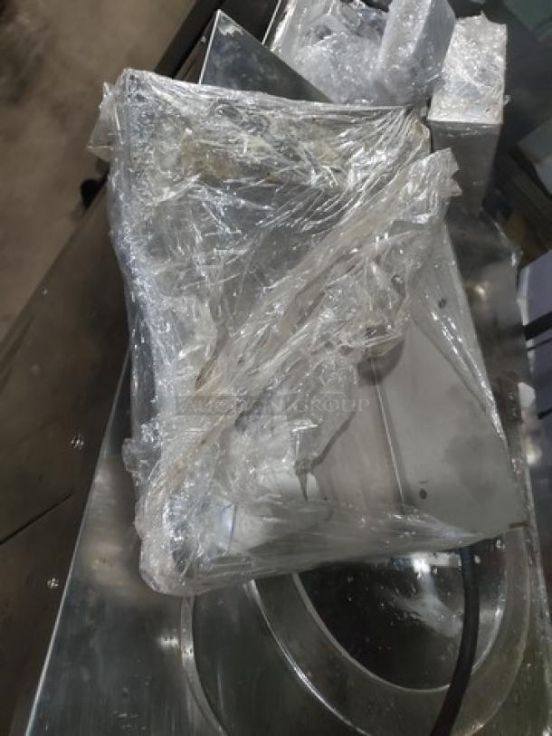 Kolice ICM 200E Ice Cream Machine wrapped in plastic, stainless steel finish, showing minor wear. Perfect for commercial use.