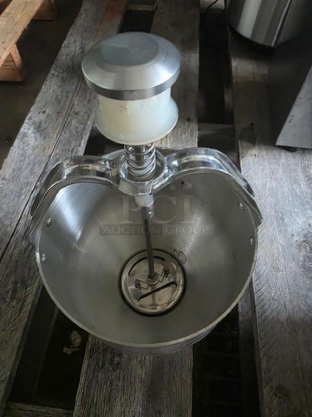 Aluminum pancake dispenser with stainless steel finish, hand crank mechanism, and large capacity. Slight surface wear visible.