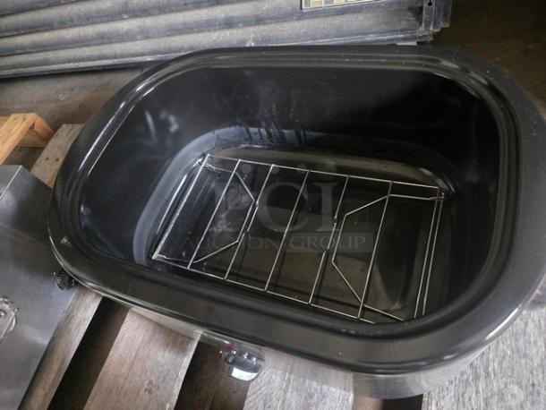 Oster 22 Qt Roaster Oven, black interior, includes metal rack. Used condition with visible wear.