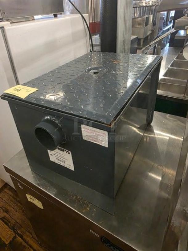Watts WD-20 Grease Interceptor, steel, 40 lb. capacity, visible markings, used condition, industrial setting.