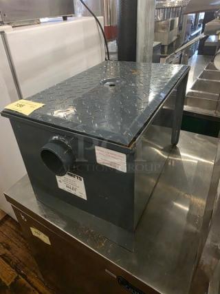 Watts WD-20 Grease Interceptor, steel, 40 lb. capacity, visible markings, used condition, industrial setting.
