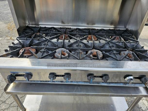 Radiance 48" 8-burner gas hotplate with stand. Features heavy-duty cast iron grates. Commercial use with visible wear.
