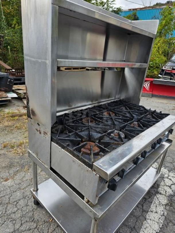 Radiance 48" 8-burner gas commercial hotplate with stand, stainless steel, showing signs of wear and rust on surface.