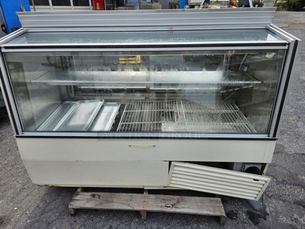 Hussmann SCD-6 Refrigerated Display Case with glass front, dual shelves, and visible wear. Ideal for commercial food display.