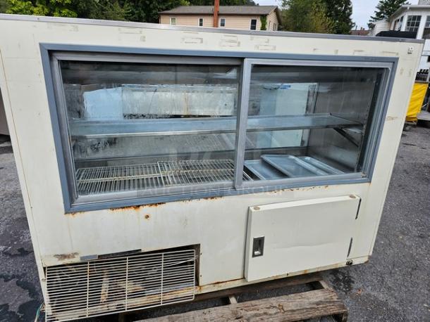 Hussmann SCD-6 refrigerated display case, shows some rust and wear, dual glass doors, shelves, used condition.
