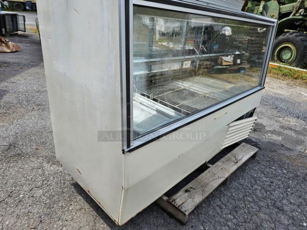 Hussmann SCD-6 refrigerated display case, glass front, metal frame, used condition, visible wear on surfaces.