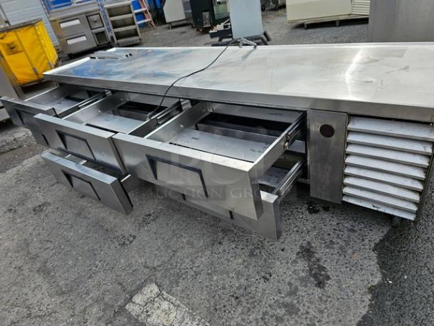 True TRCB-110 Six-Drawer Chef Base Refrigerator, 110". Stainless steel, used, open drawers, visible cooling unit, durable.
