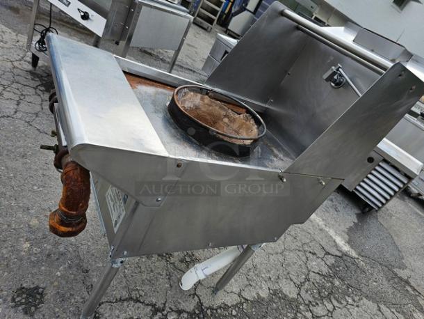 Single burner natural gas wok range in stainless steel, used condition, rust on gas pipe, commercial kitchen equipment.