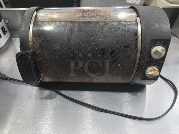Vintage toaster oven model 168955, cylindrical design, black exterior, visible wear and stains, dial controls on the side.