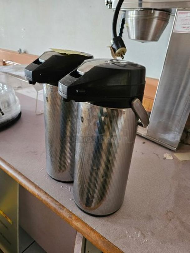 Lot of two Newco Thermal Airpots in stainless steel, excellent condition. Features include black lids and spouts. Model 2XBID.