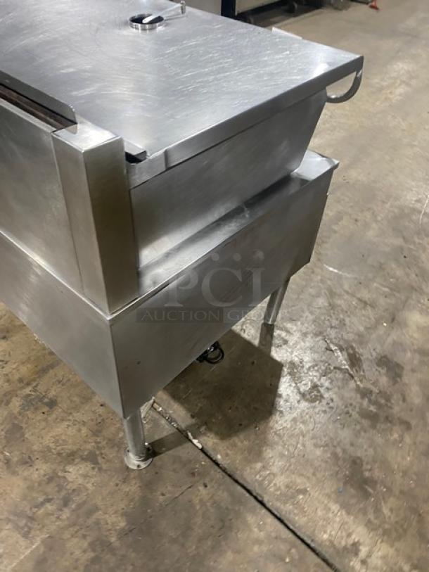 Commercial stainless steel electric braising pan with swivel faucet on legs, features a tilted design, in good condition.