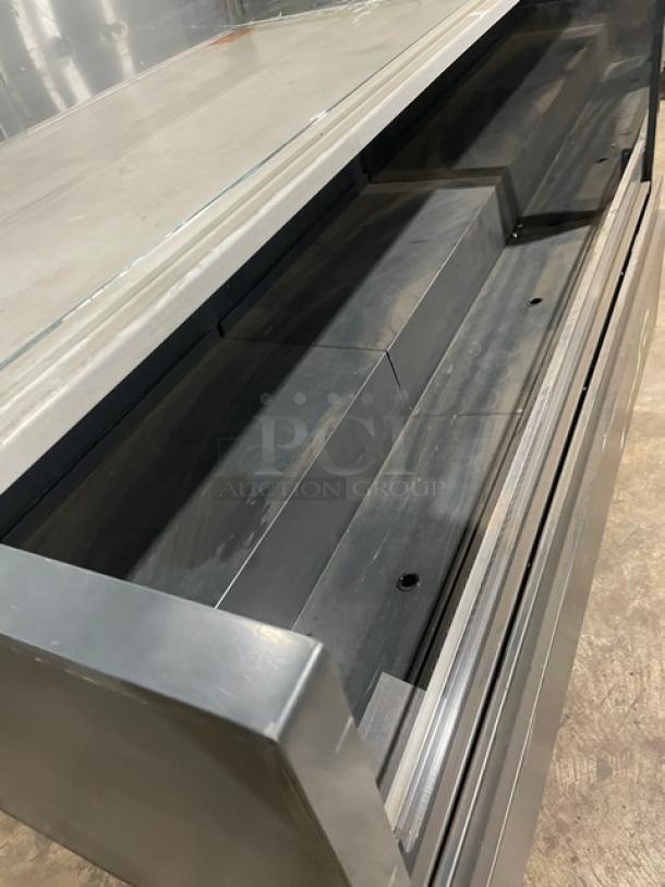 Structural Concepts black refrigerated display case, multi-level with enclosed glass showcase. Top view, on legs, used condition.