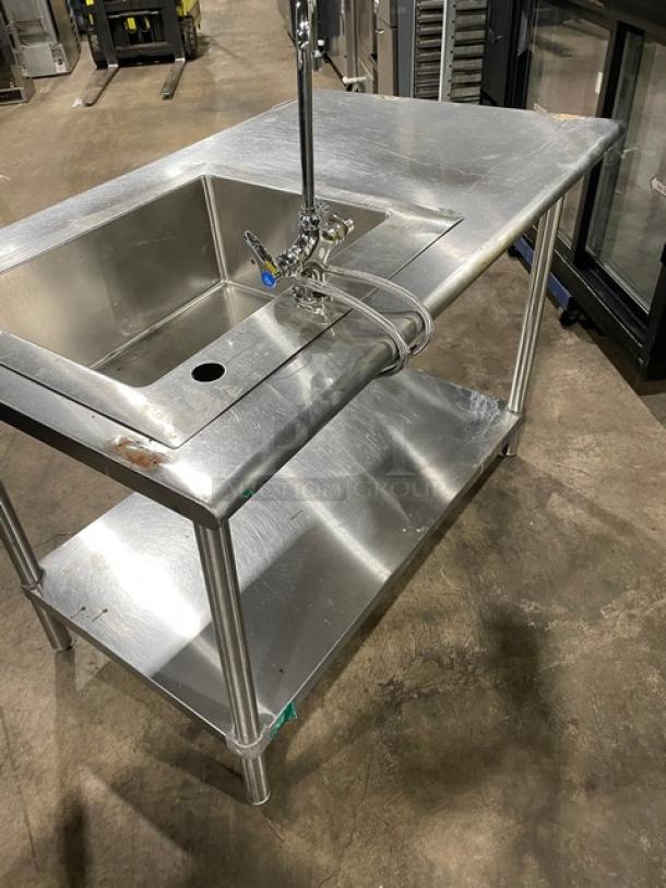 Commercial stainless steel sink workstation with single-compartment, gooseneck swivel faucet, undershelf, and sturdy legs.