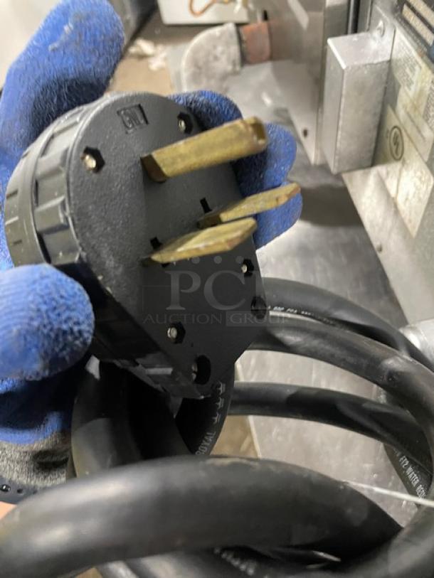Close-up of a three-prong power plug for TurboChef HHB commercial rapid cook oven, showing connection details.