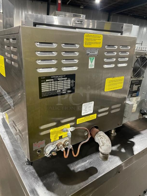 Cleveland Range Model 21CET8 stainless steel 3-pan convection steamer. Features include electric power, built-in pan rack, and 208V 3-phase compatibility. Serial: WC03837-07J-02. Mounted on legs with visible labels and markings.