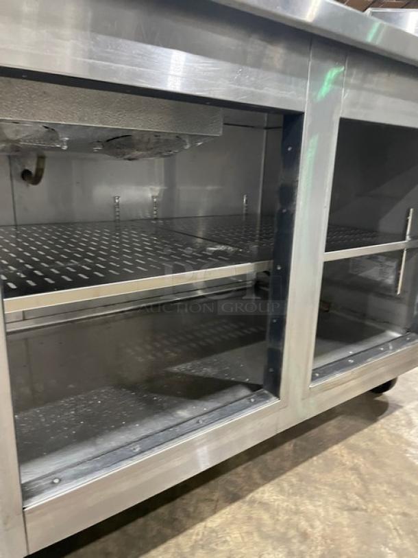 Marsal BM72R stainless steel 3-door refrigerated pizza prep table with built-in pan slides and shelving, on casters.