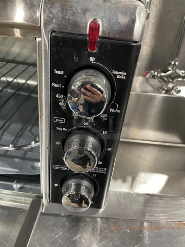 BLACK+DECKER TO3250XSB toaster oven with control dials, stainless steel finish, extra wide interior, on counter.