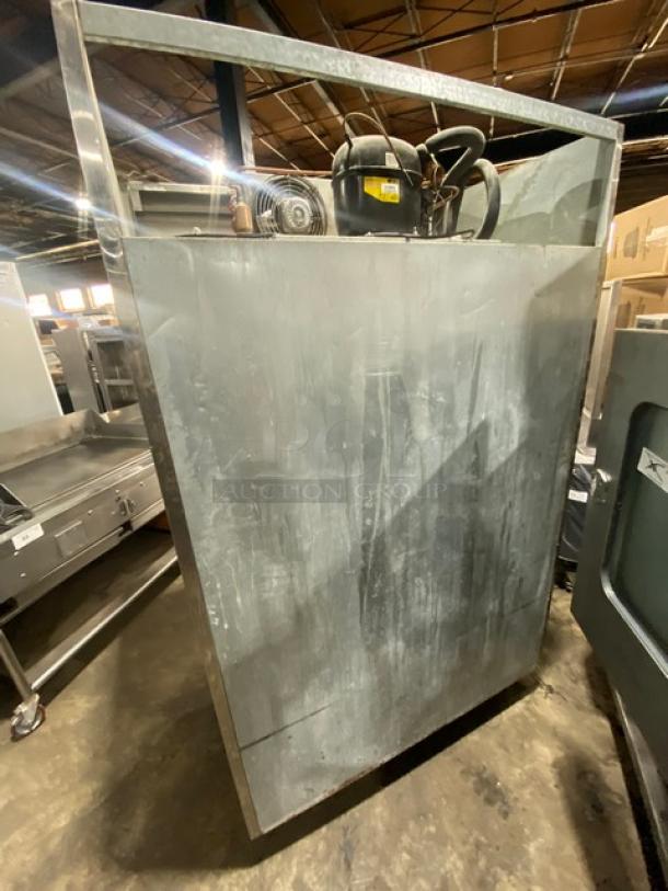 Commercial stainless steel double half-door reach-in refrigerator, features poly-coated wire rack, on casters, used condition.