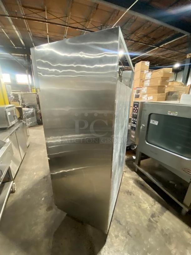 Commercial stainless steel double half-door refrigerator, features poly-coated wired rack, mounted on casters, in good condition.