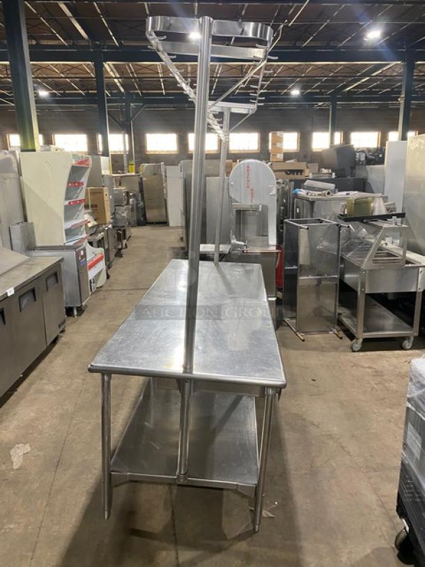 Commercial stainless steel worktop table with undershelf, overhead pots and pans rack, pull-out storage drawer, on legs.