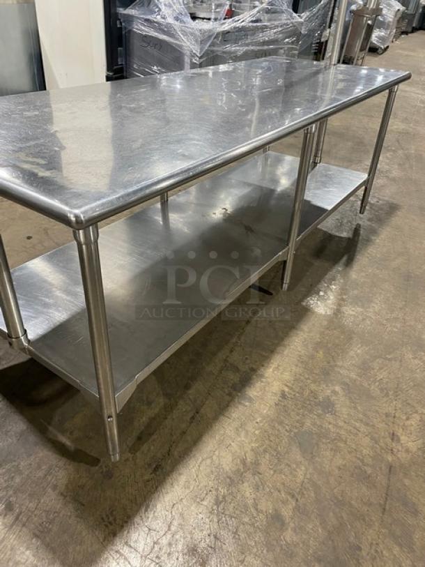 Commercial stainless steel worktop table with undershelf, overhead rack, pull-out drawer, and sturdy legs.