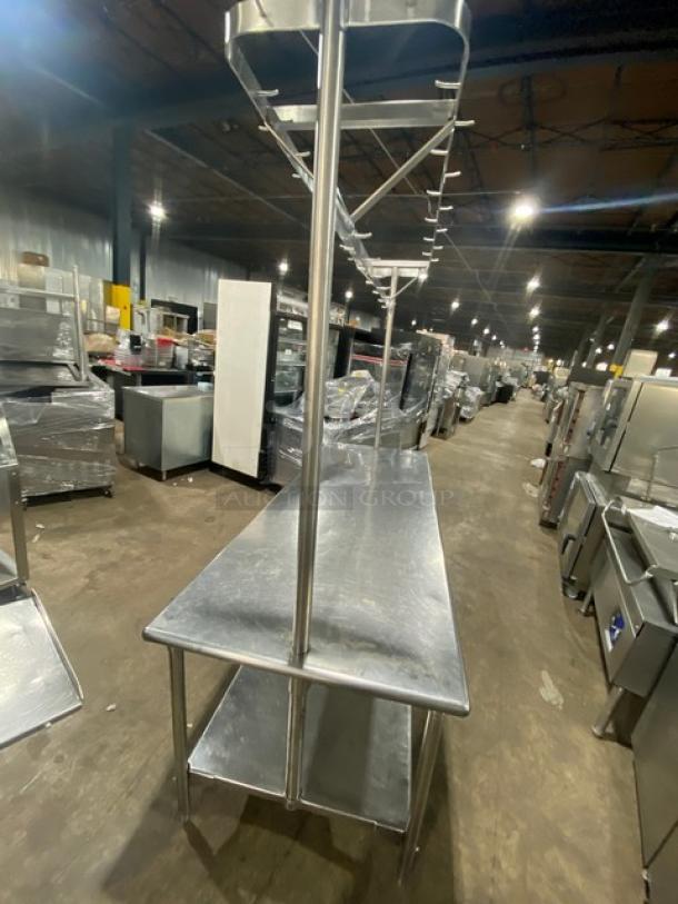 Commercial stainless steel worktop table with undershelf, overhead pots rack, and pull-out drawer. Appears in good condition.