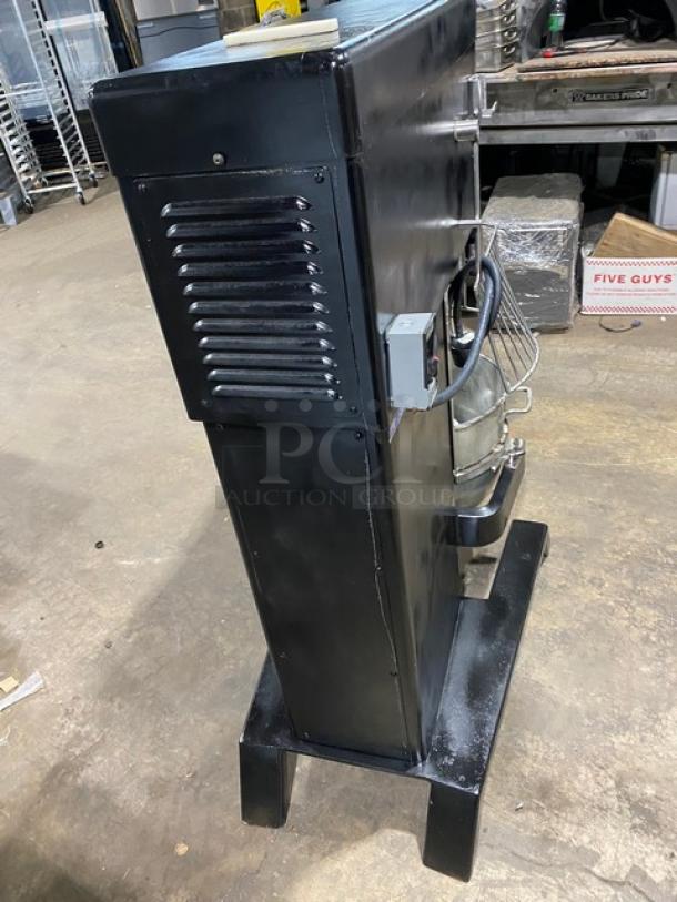Blakeslee black heavy-duty planetary mixer, electric-powered, with stainless steel bowl guard, mixing bowl, and spiral hook attachment.
