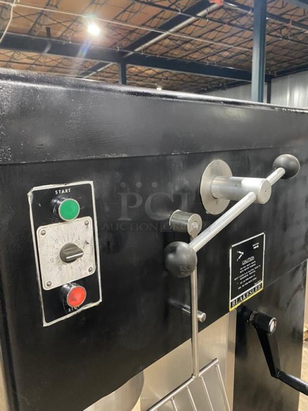 Blakeslee commercial black electric planetary mixer with stainless steel bowl guard, mixing bowl, and spiral hook attachment.