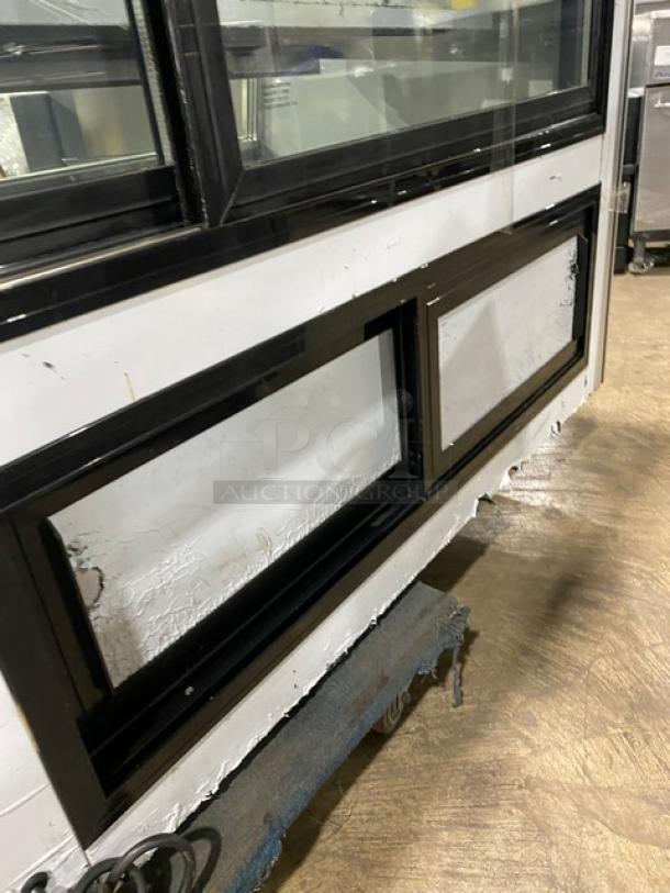 Leader ERHD72ES stainless steel refrigerated merchandiser, 72" slanted glass, adjustable shelves, lower storage, visible wear.