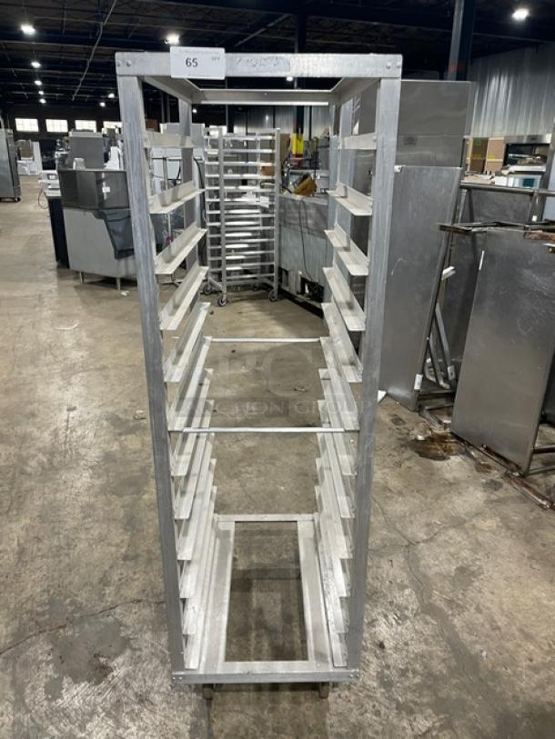 Commercial aluminum pan rack with multiple shelves on casters for easy transport, used condition. Label: "65."